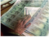 A hand over print sheets of British pounds.